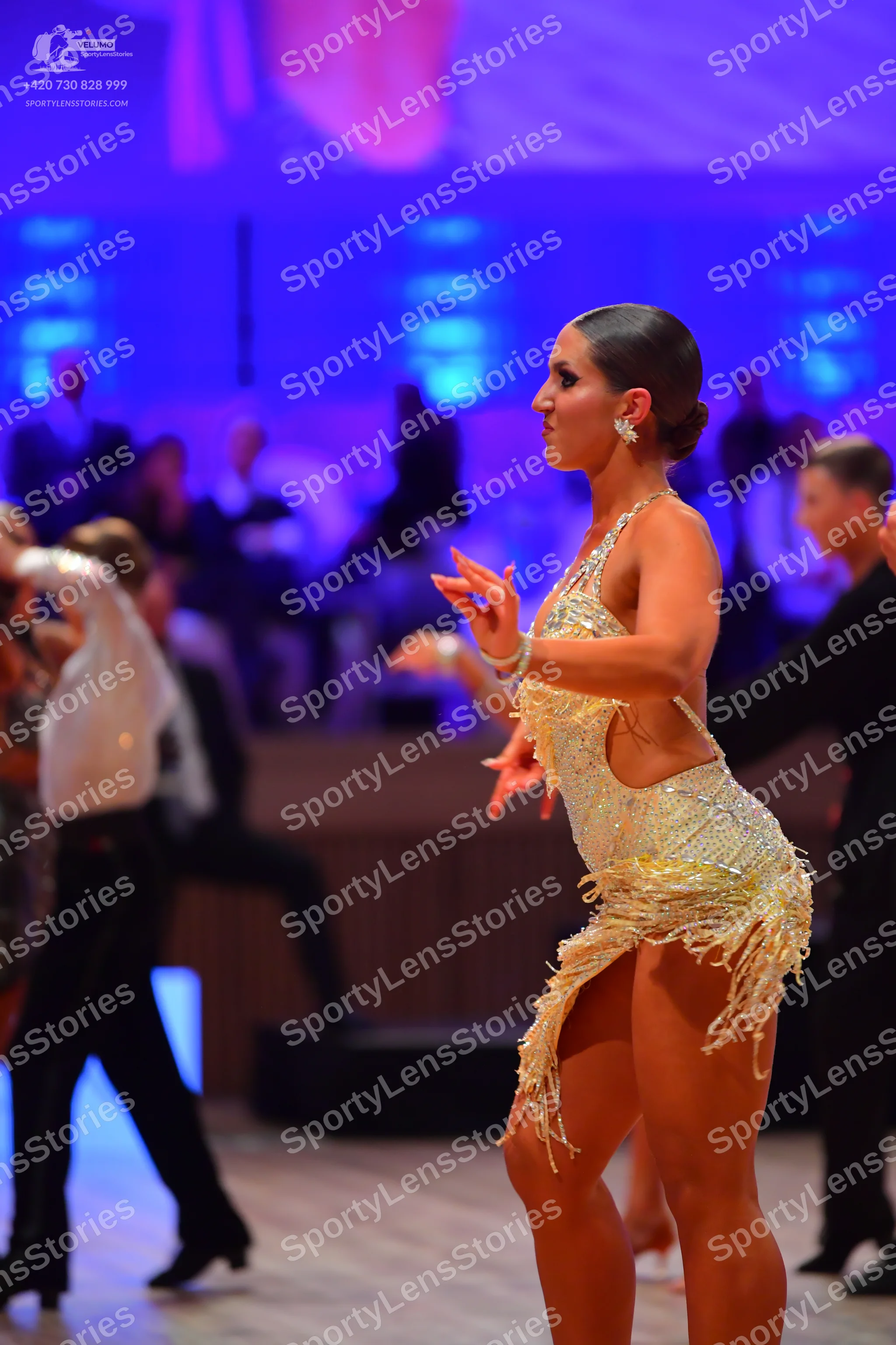 Dancesport competitor: Female dancer: light gold sequined Latin dress with fringe