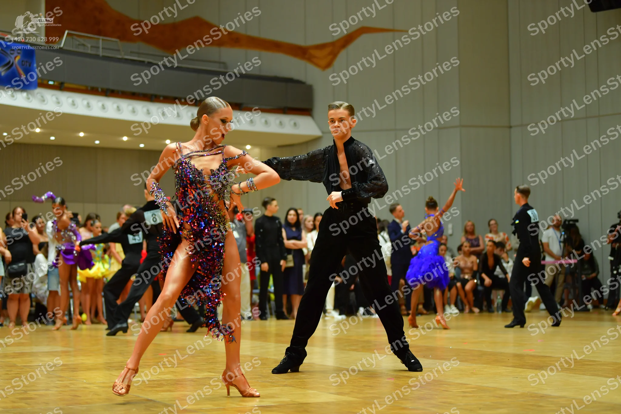 Dancesport competitor: Female dancer: dark purple/blue latin dress with heavy sequin/beaded embellishme