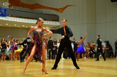 Dancesport competitor: Female dancer: dark purple/blue latin dress with heavy sequin/beaded embellishme