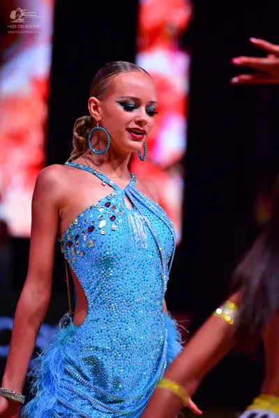 Dancesport competitor: Female dancer: light blue sequin latin dress with a halter neck, side cutouts, a