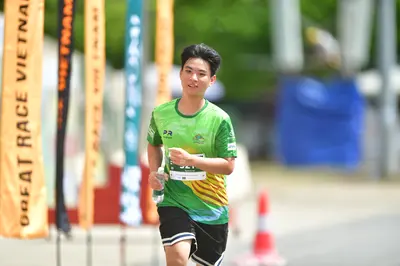 Marathon runner: Runner 1: green jersey with yellow/orange patterns, black shorts with white stri