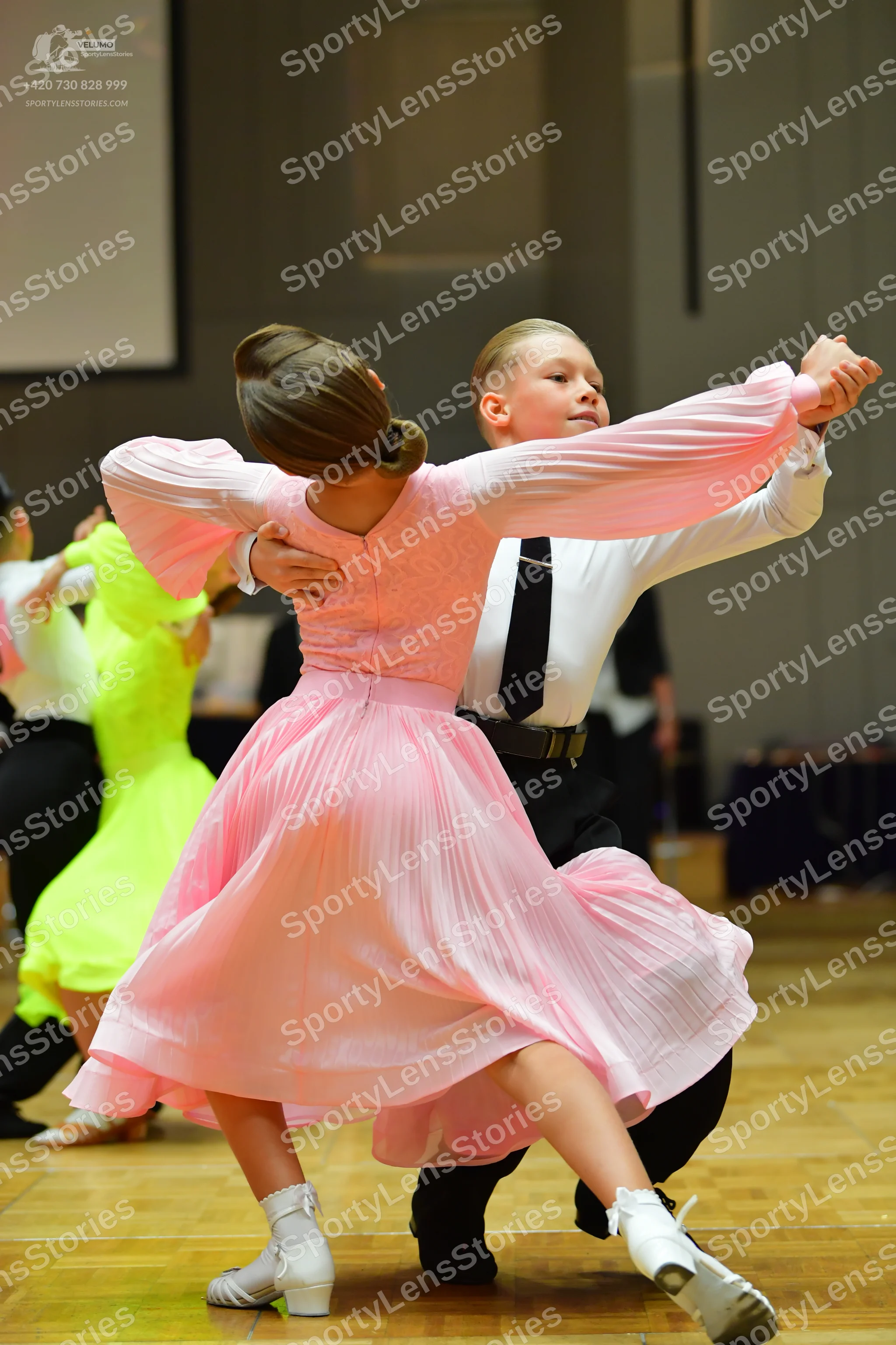 Dancesport competitor: Female dancer: light pink, long-sleeved ballgown with a flowing skirt