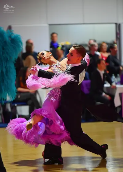 Dancesport competitor: Female dancer: bright pink Latin dance dress with a sequined bodice and large, v