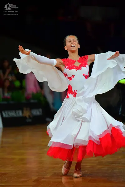 Dancesport competitor: Female dancer: white ballroom dress with red lace/embroidery on the bodice and a