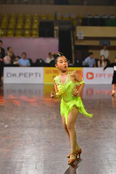 Dancesport competitor: Female dancer: lime green Latin dance dress with sequins and a layered, fringe-l