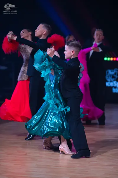 Dancesport competitor: Male dancer in foreground: black suit with long sleeves and black trousers