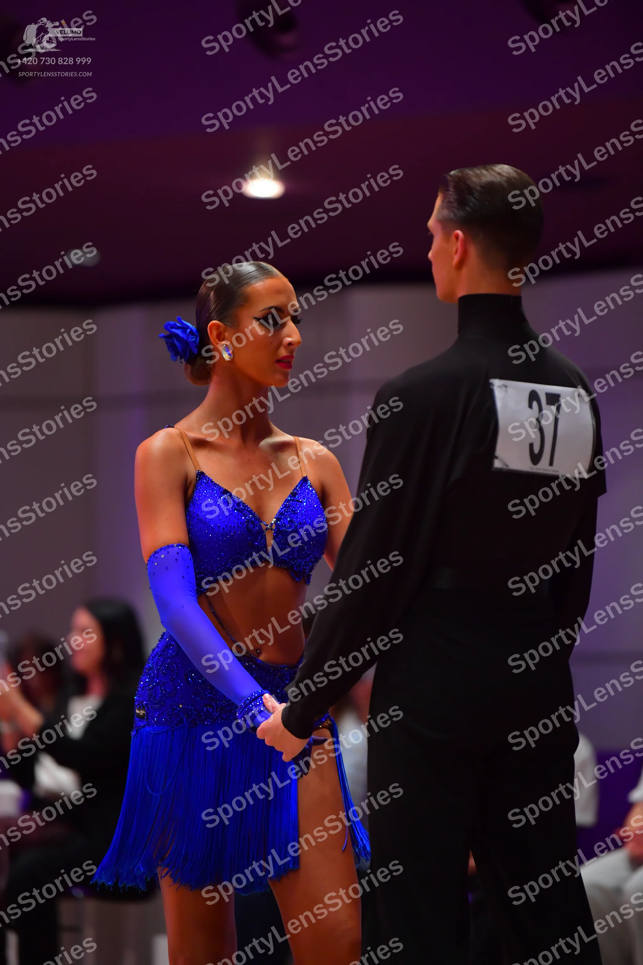 Dancesport competitor: Female dancer: blue latin dress with sequins and fringe, a matching blue long gl