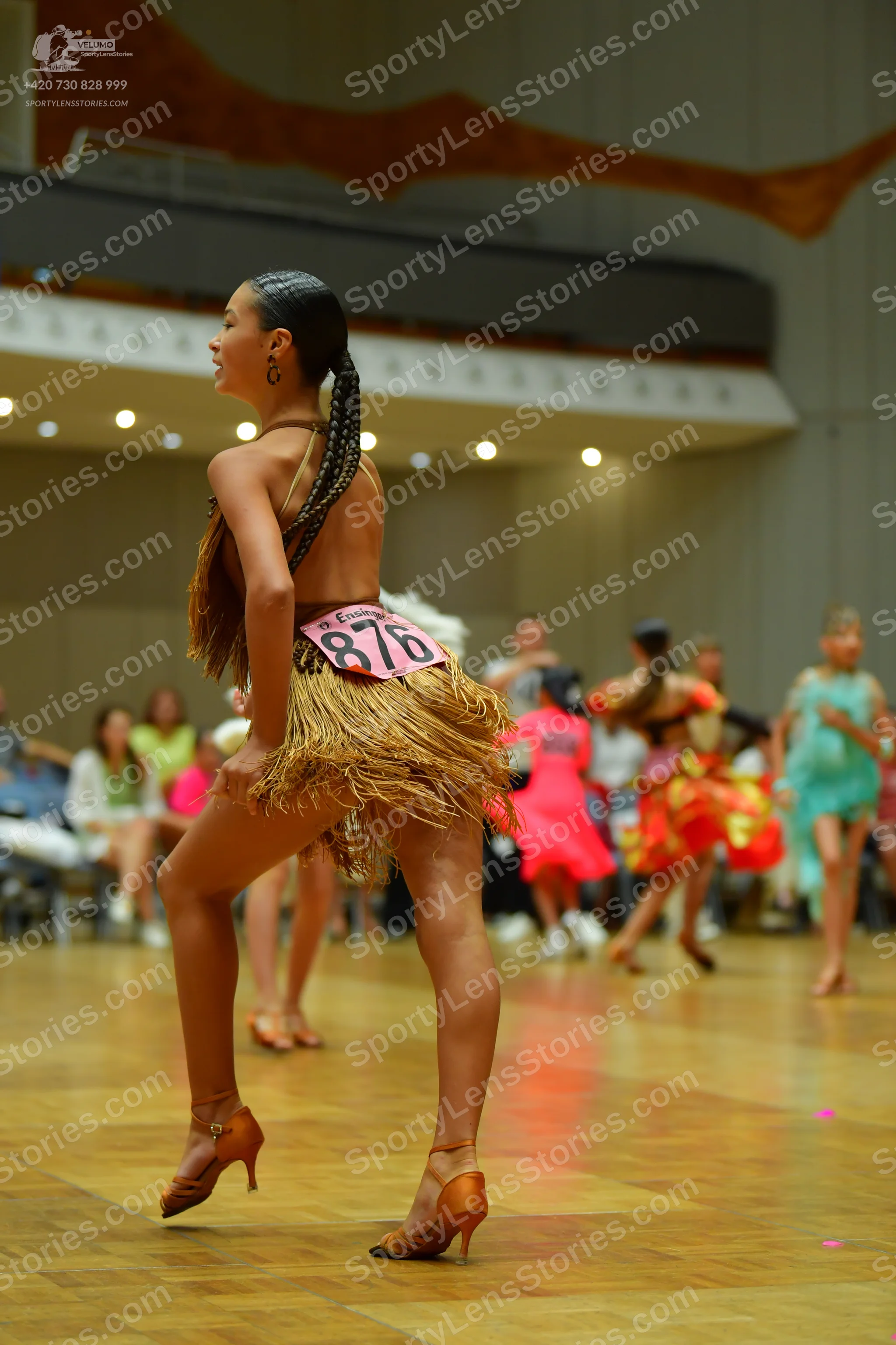 Dancesport competitor #876: Foreground dancer: brown Latin dance costume with a strappy top and a long fring