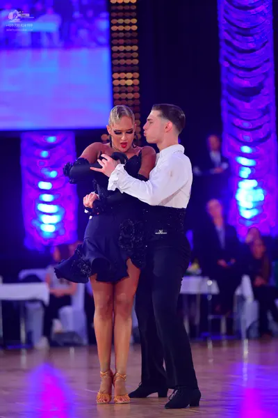 Dancesport competitor: Male dancer: white long-sleeved shirt, black trousers, and a black cummerbund