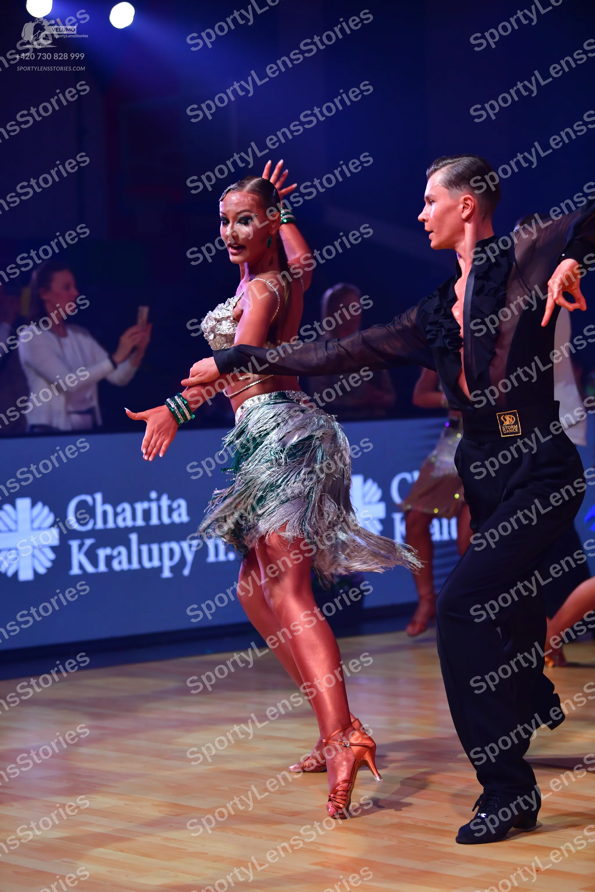 Dancesport competitor: Female dancer: silver and green Latin dance dress featuring sequins, crystals, a
