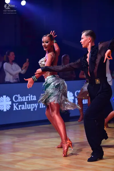 Dancesport competitor: Female dancer: silver and green Latin dance dress featuring sequins, crystals, a