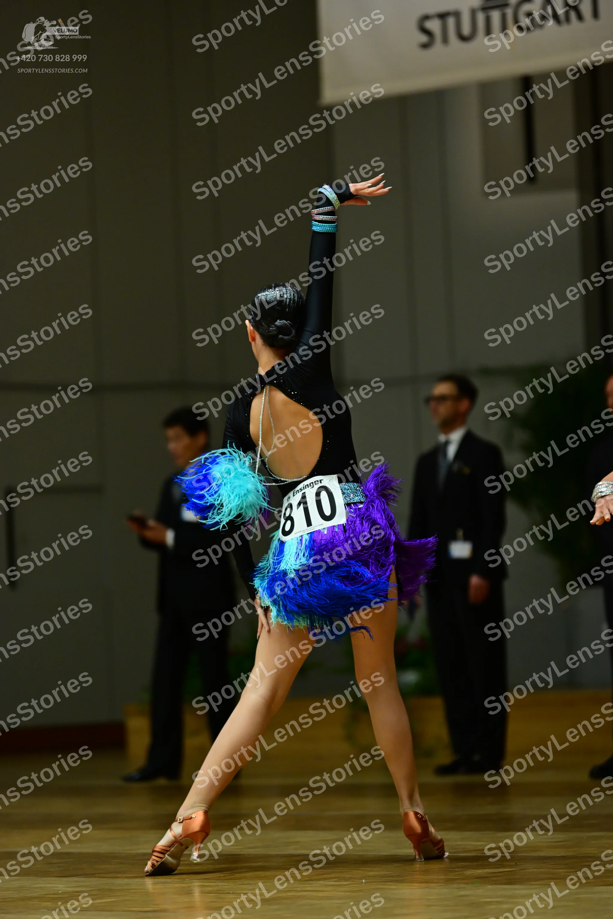 Dancesport competitor #810: Female dancer: black latin dress with long sleeves, an open back, and a vibrant 