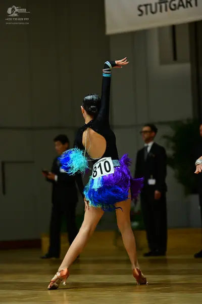 Dancesport competitor #810: Female dancer: black latin dress with long sleeves, an open back, and a vibrant 