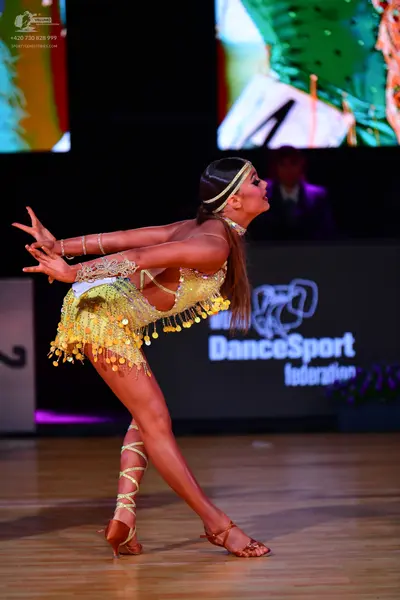 Dancesport competitor: Female dancer: yellow and lime green latin dance costume with sequins, long frin
