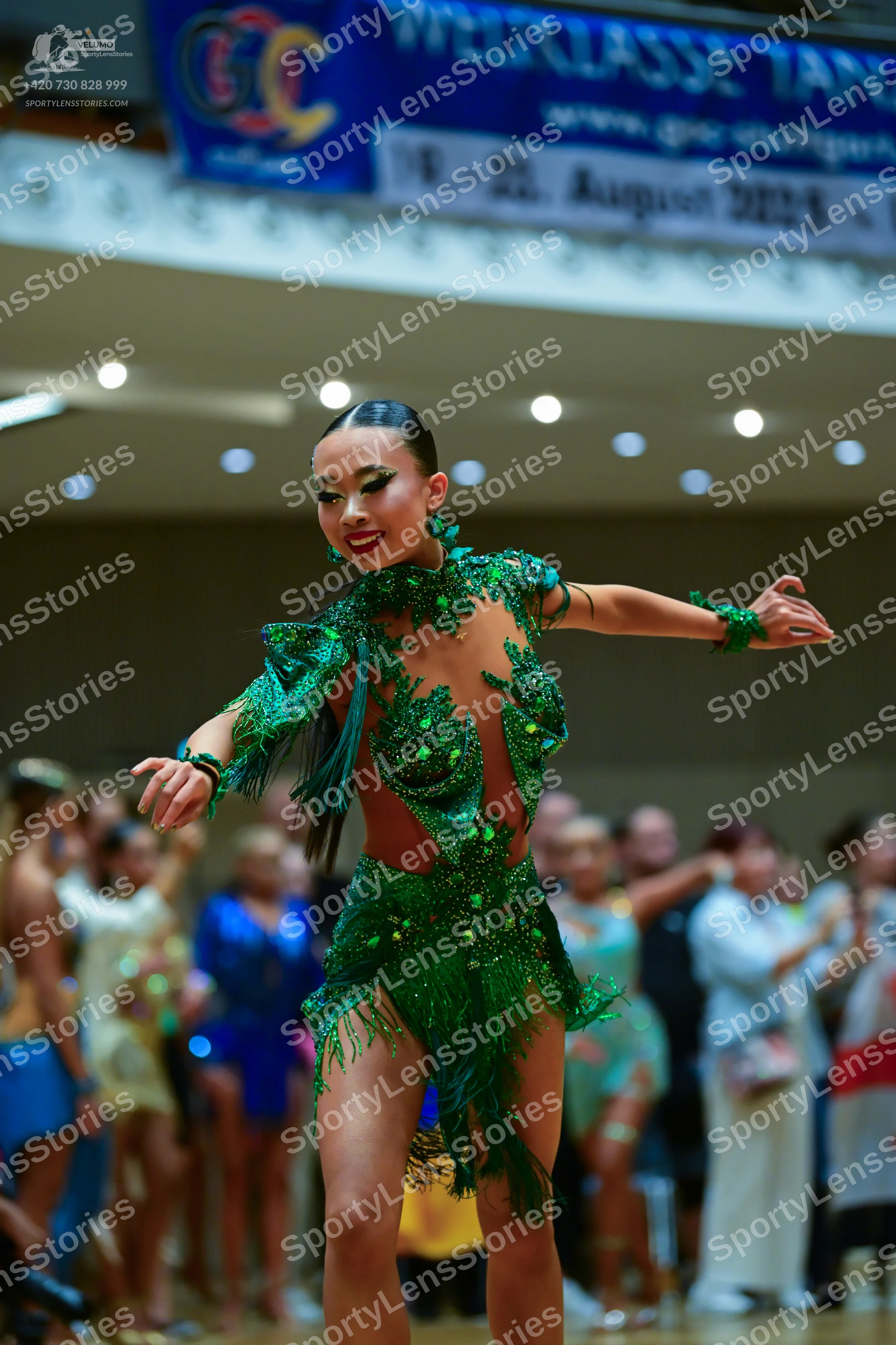Dancesport competitor: Main dancer: emerald green Latin dress with fringe, sequins, and emerald-colored
