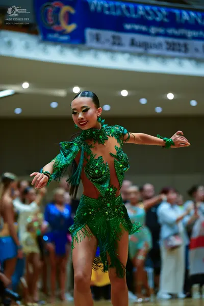 Dancesport competitor: Main dancer: emerald green Latin dress with fringe, sequins, and emerald-colored