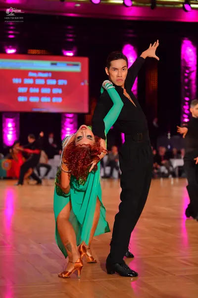 Dancesport competitor: Male dancer: black long-sleeved Latin dance top with silver/white embellishments
