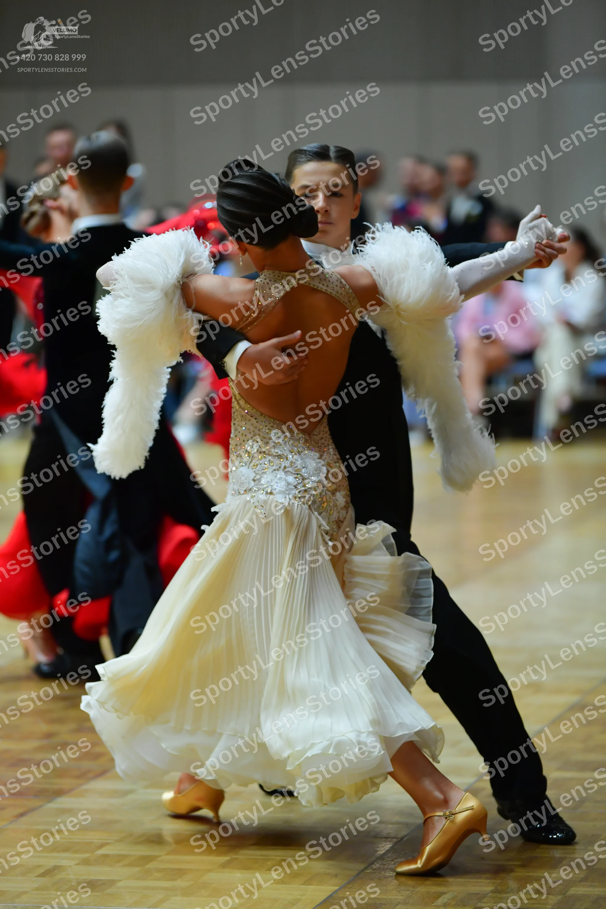 Dancesport competitor: Female dancer: cream-colored ballroom dress with a sequined and lace bodice, a f