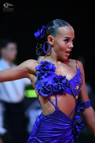 Dancesport competitor: Female dancer: blue satin Latin dress featuring 3D fabric flowers on the bodice 