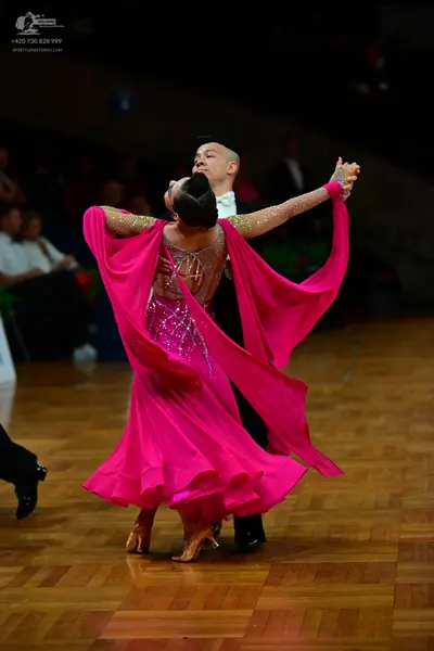 Dancesport competitor: Female dancer: bright pink latin dress with silver sequins on the bodice and lon