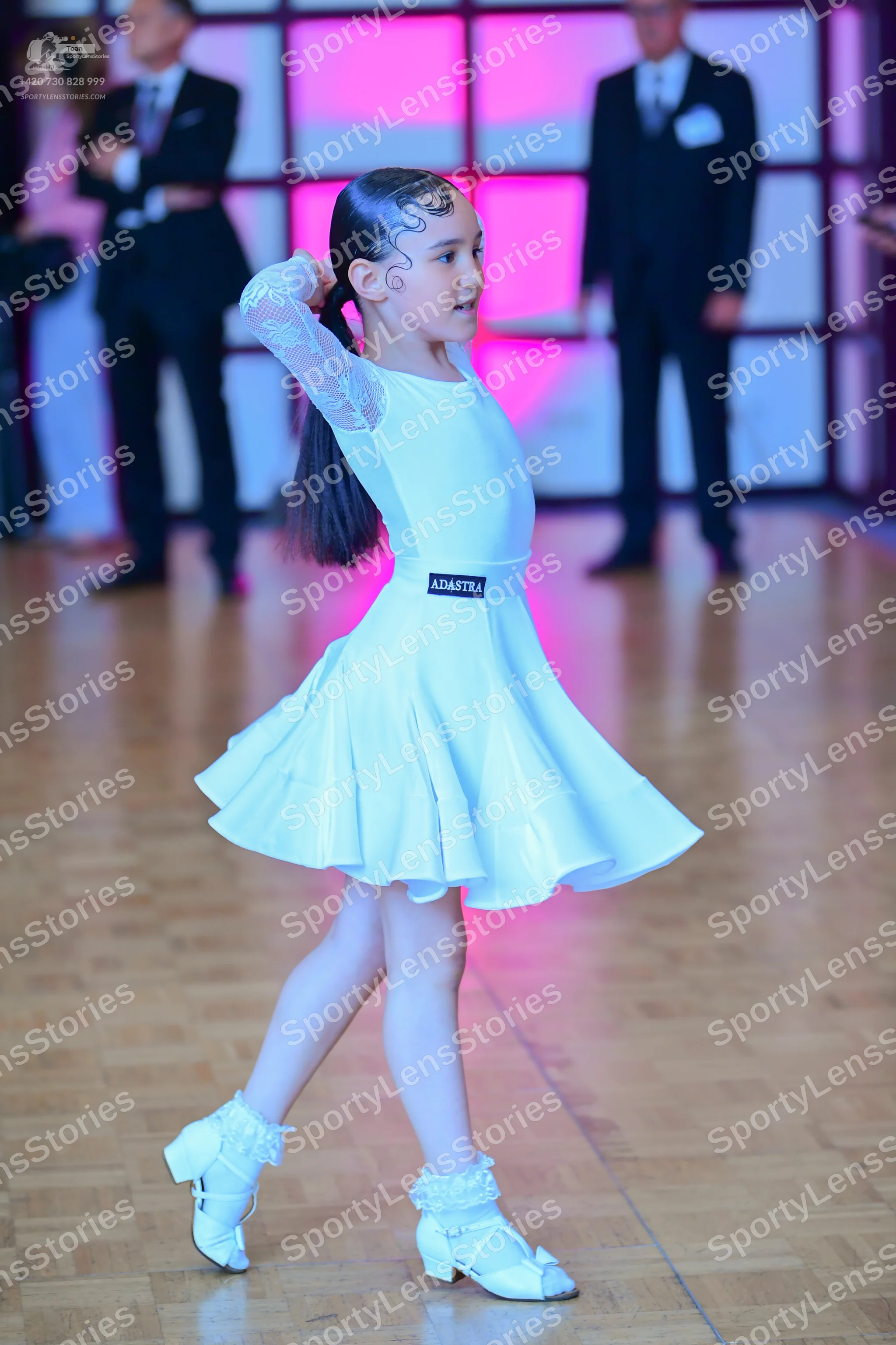 Dancesport competitor: Female dancer: white long-sleeved dress with lace sleeves and a flared skirt, pa