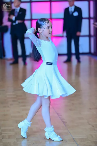 Dancesport competitor: Female dancer: white long-sleeved dress with lace sleeves and a flared skirt, pa