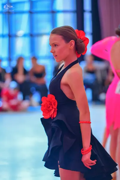 Dancesport competitor: Female dancer: black halter-neck latin dress with ruffles and large red floral a