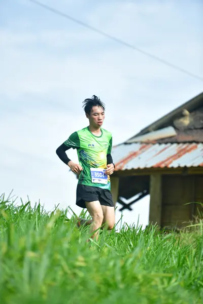 Marathon runner #394: Runner 1: green jersey, black shorts