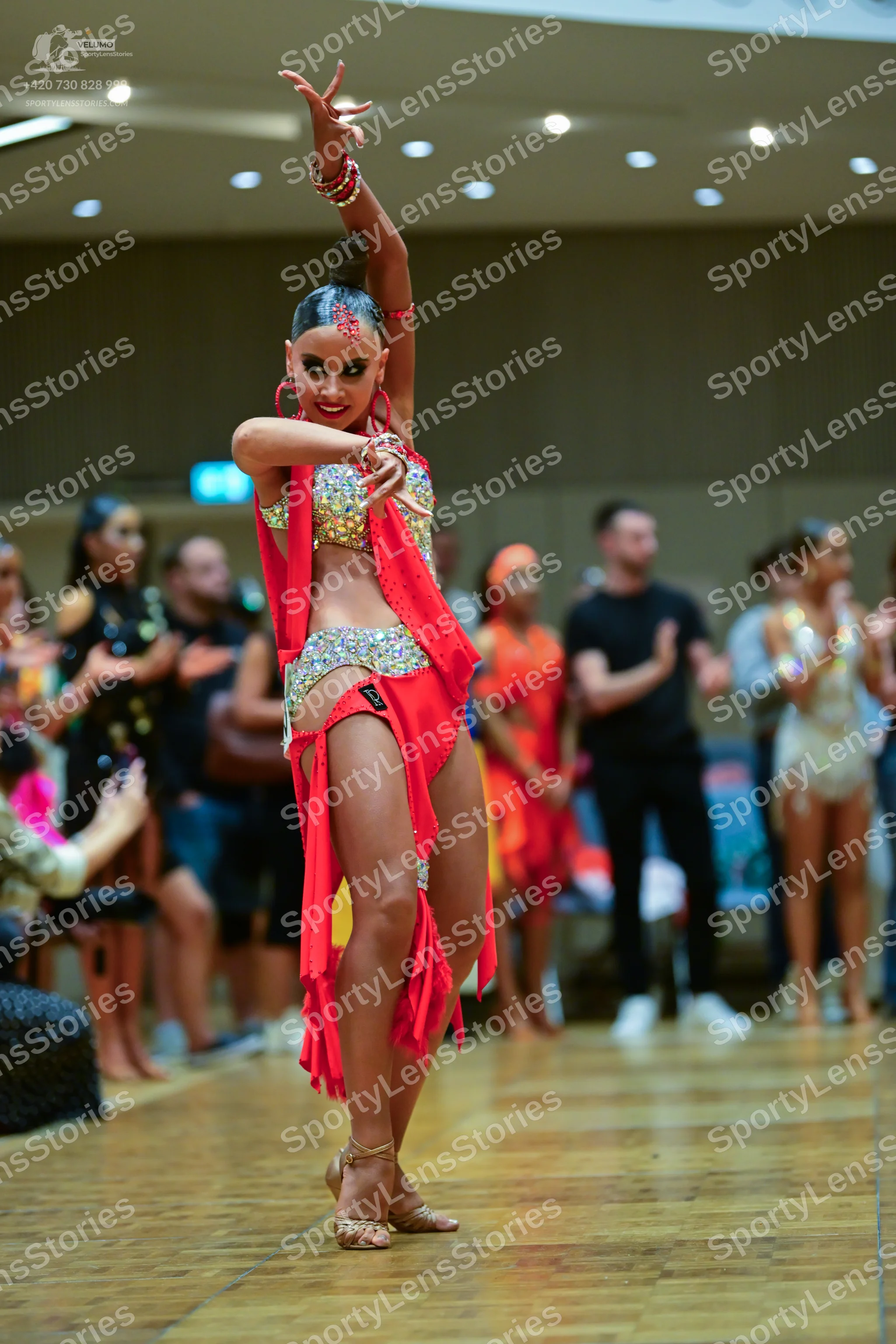 Dancesport competitor: Main female dancer: red Latin dance costume featuring a silver and gold sequined