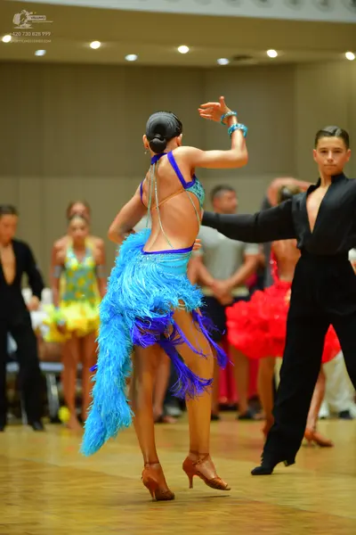 Dancesport competitor: Female dancer: blue Latin dress with sequins and long blue and purple fringe