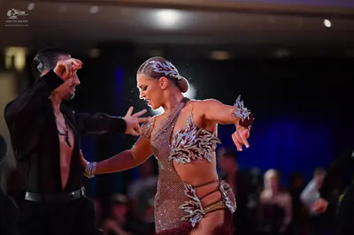 Dancesport competitor: Male dancer: black long-sleeved dance shirt, open at the chest, with a dark pend