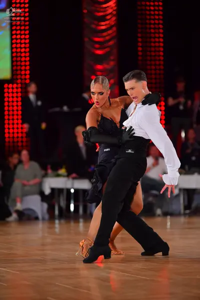 Dancesport competitor: Male dancer: white long-sleeved shirt, black trousers, and black gloves