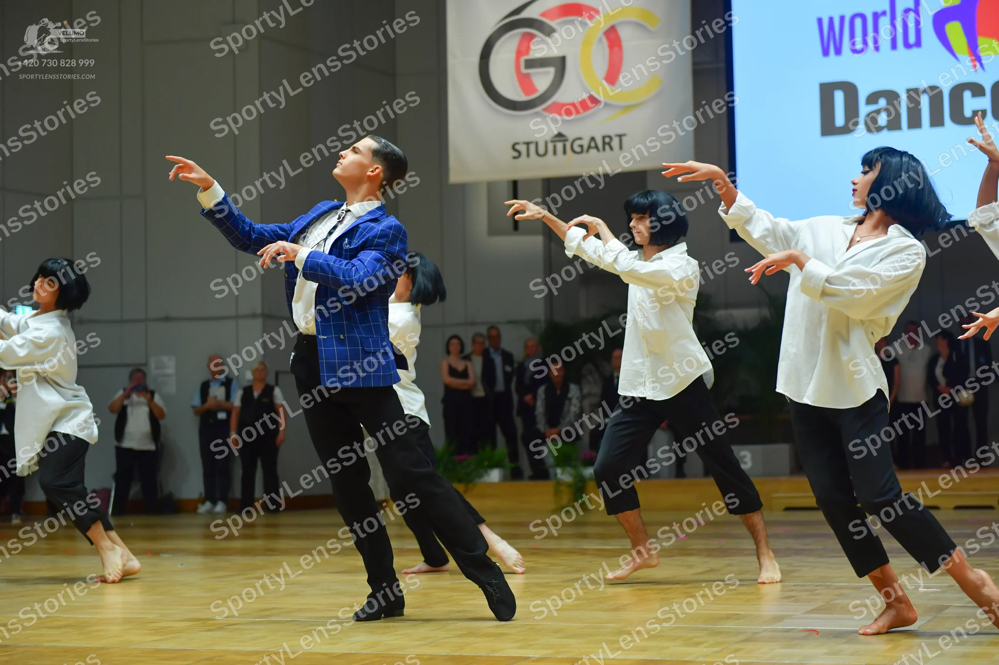 Dancesport competitor: Male dancer: blue patterned jacket, black trousers, and black shoes