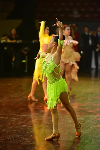 Dancesport competitor: Female dancer: lime green latin dress with fringe and sequins