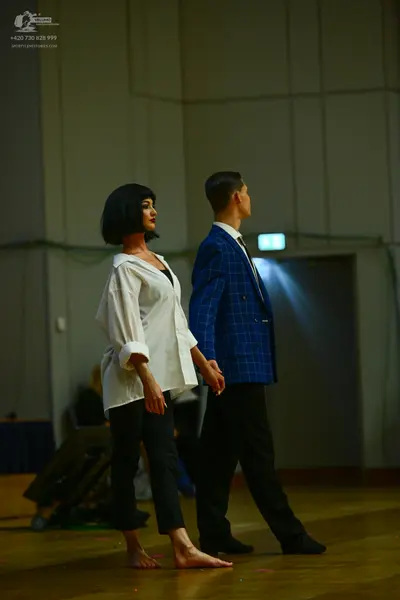Dancesport competitor: Female dancer: white long-sleeved shirt and black trousers