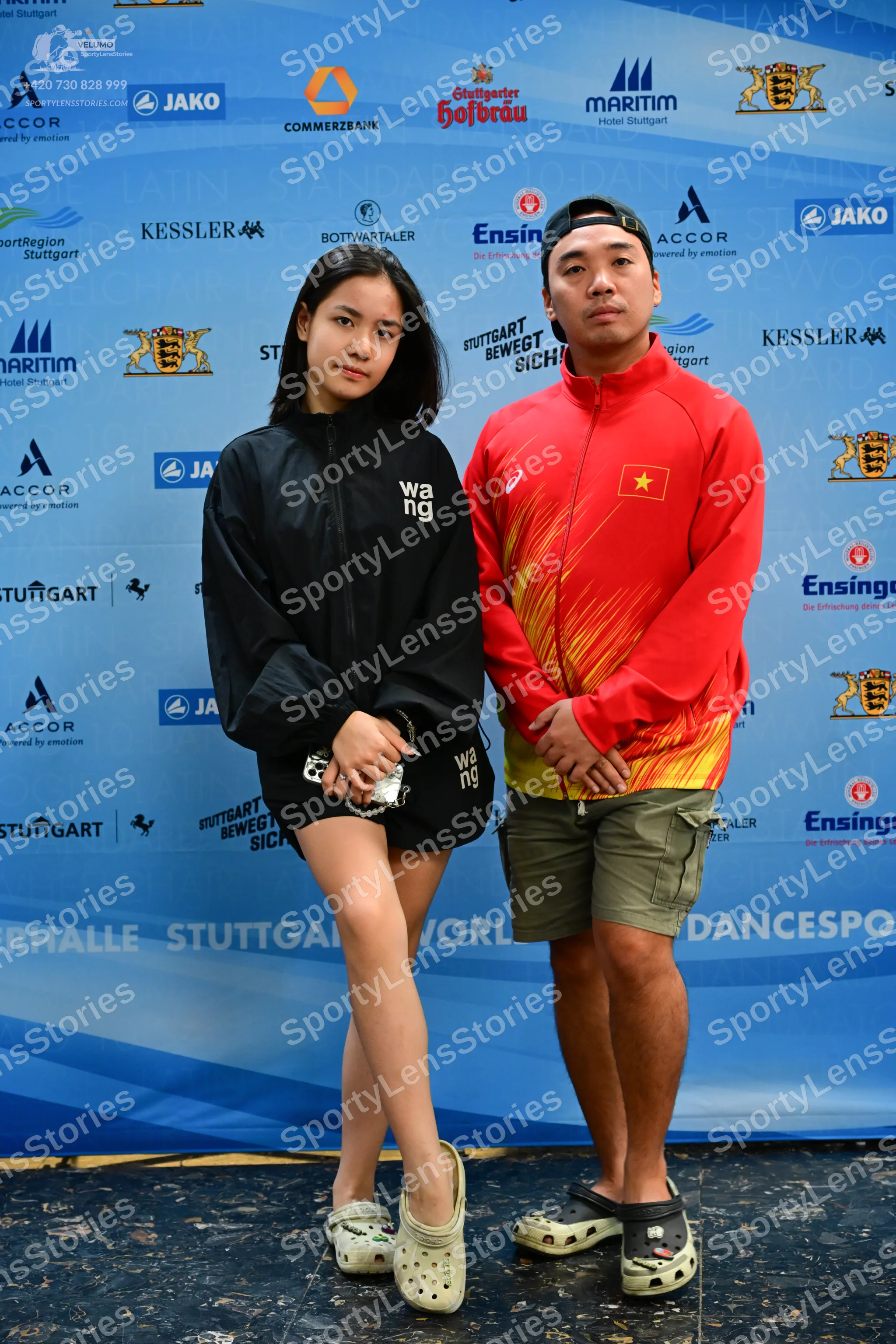 Dancesport competitor: Female dancer: black long-sleeved jacket and black shorts with "wang" printed on