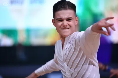 Dancesport competitor: Male dancer: white long-sleeved shirt with textured vertical folds