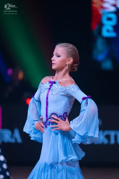 Dancesport competitor: Female dancer: light blue ballroom dress with long, flowy sleeves, featuring pur