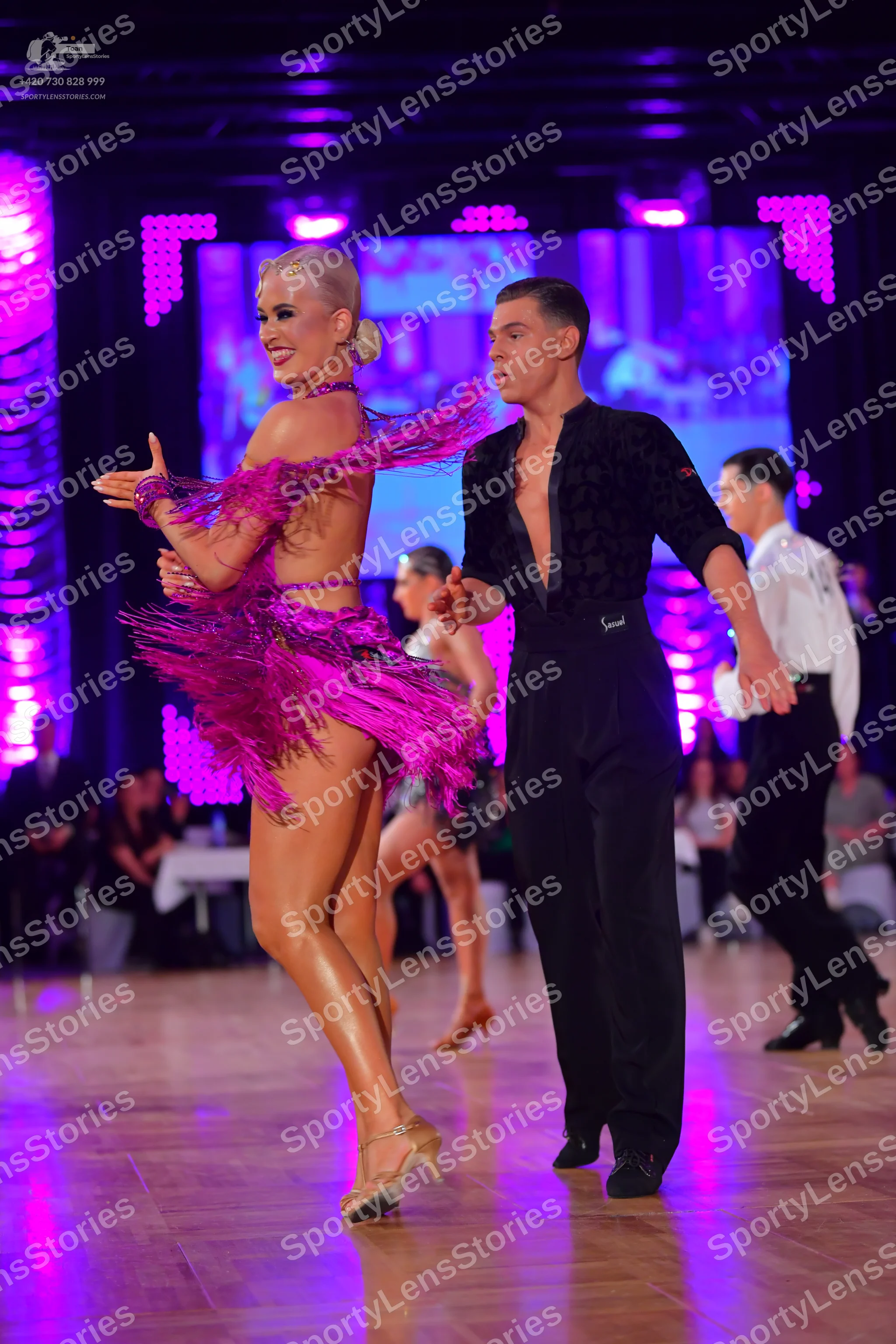 Dancesport competitor: Female dancer: bright pink Latin dress with fringe