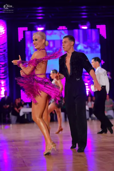 Dancesport competitor: Female dancer: bright pink Latin dress with fringe