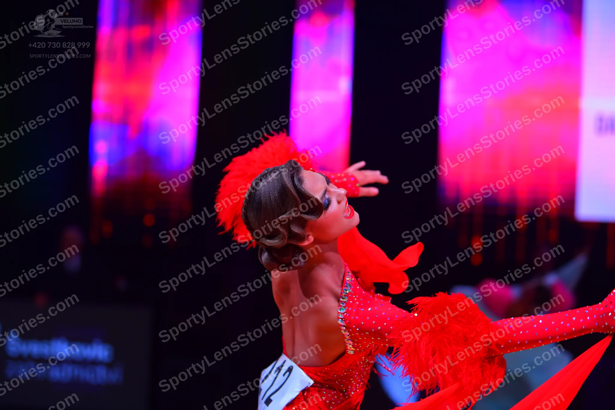 Dancesport competitor: Female dancer: red sequin latin dress with red feathers