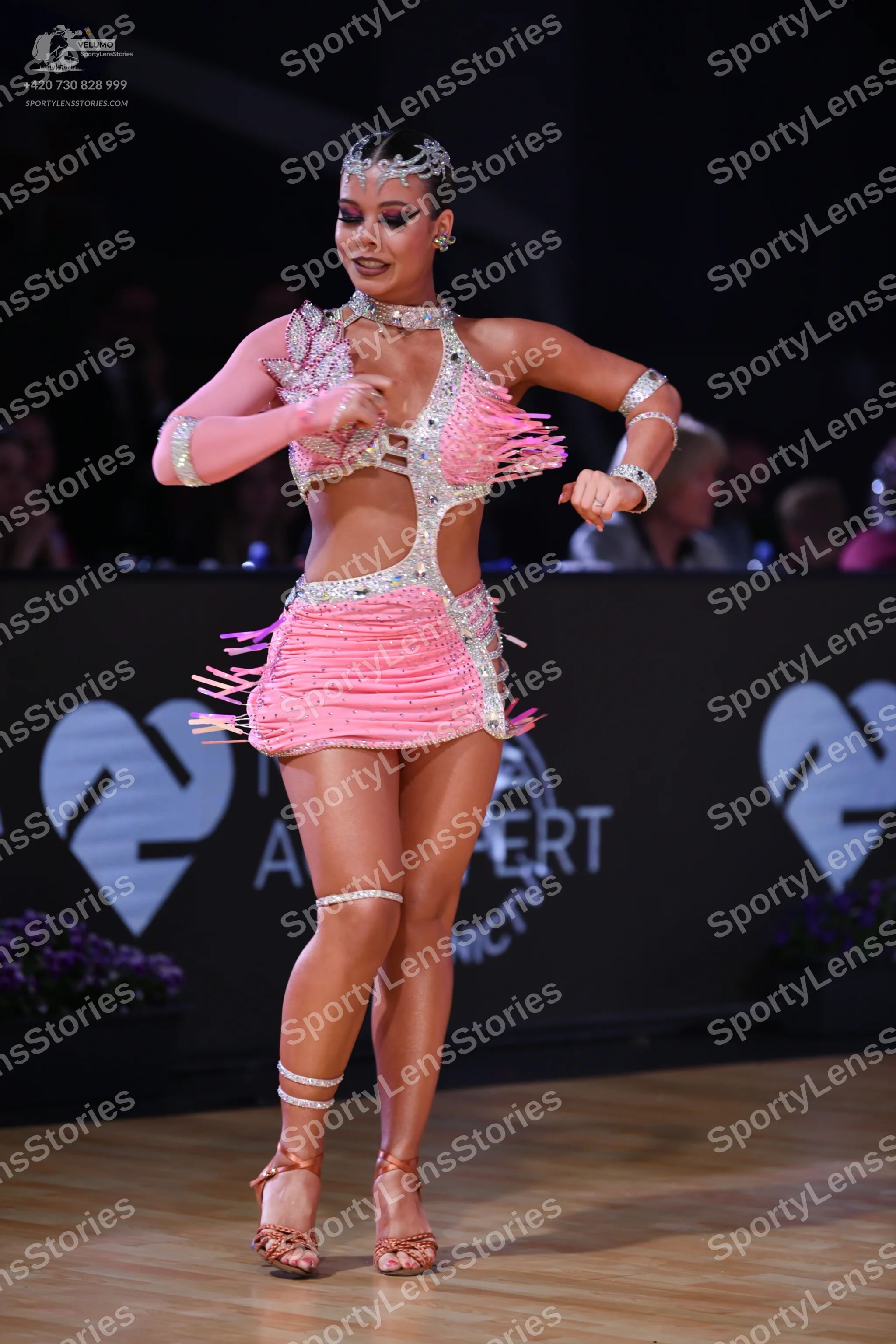 Dancesport competitor: Female dancer: pink Latin dress with silver/rhinestone embellishments and fringe