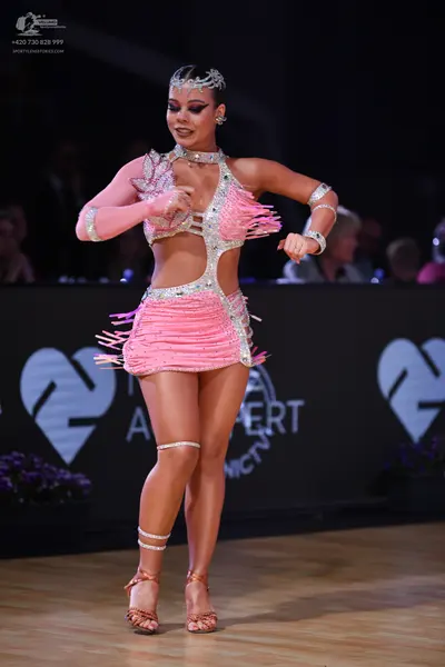 Dancesport competitor: Female dancer: pink Latin dress with silver/rhinestone embellishments and fringe