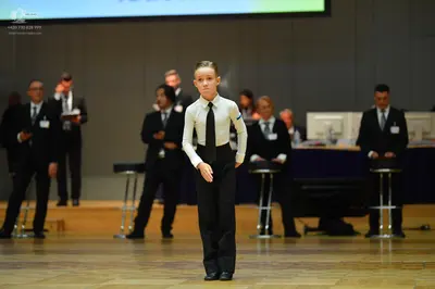 Dancesport competitor: Female dancer: white long-sleeved shirt, black necktie, and black trousers