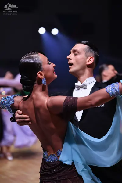 Dancesport competitor: Female dancer: backless dark brown latin dress with blue sequined patterns and l