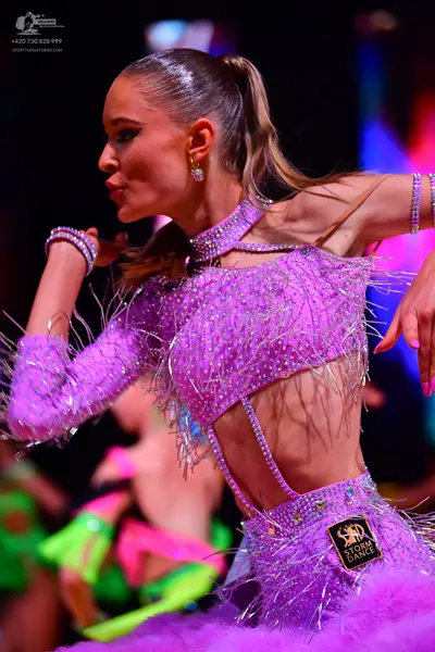 Dancesport competitor: Female dancer in foreground: lavender Latin dance dress with heavy sequin embell