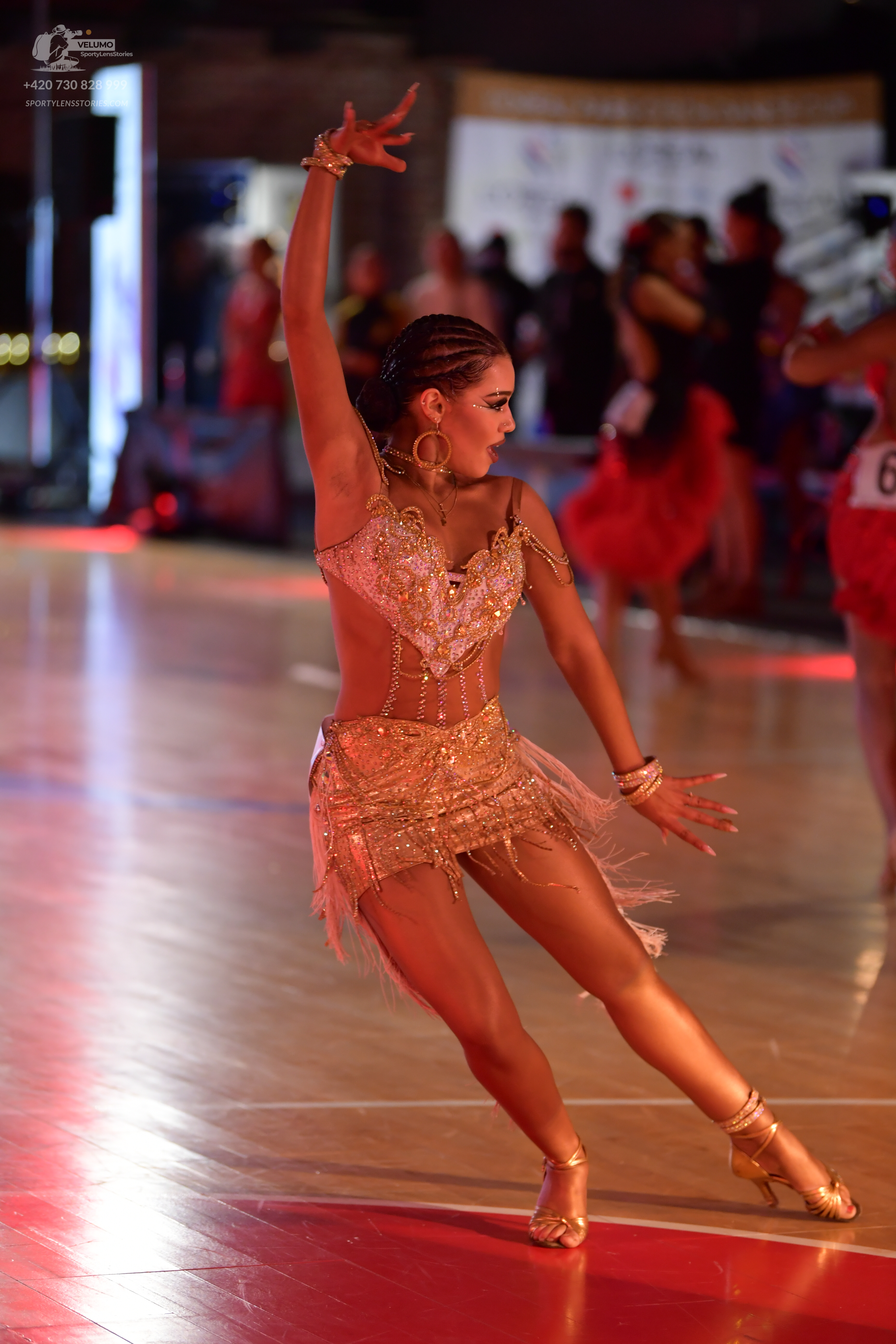 Dancesport competitor: Main female dancer: gold Latin dance dress embellished with sequins and beads, f