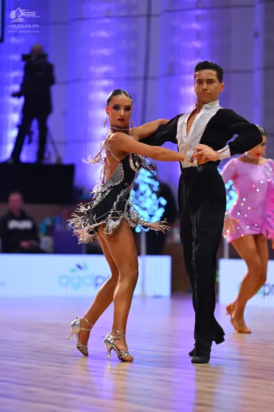 Dancesport competitor: Female dancer: black and silver latin dress with sequins and fringe-like details