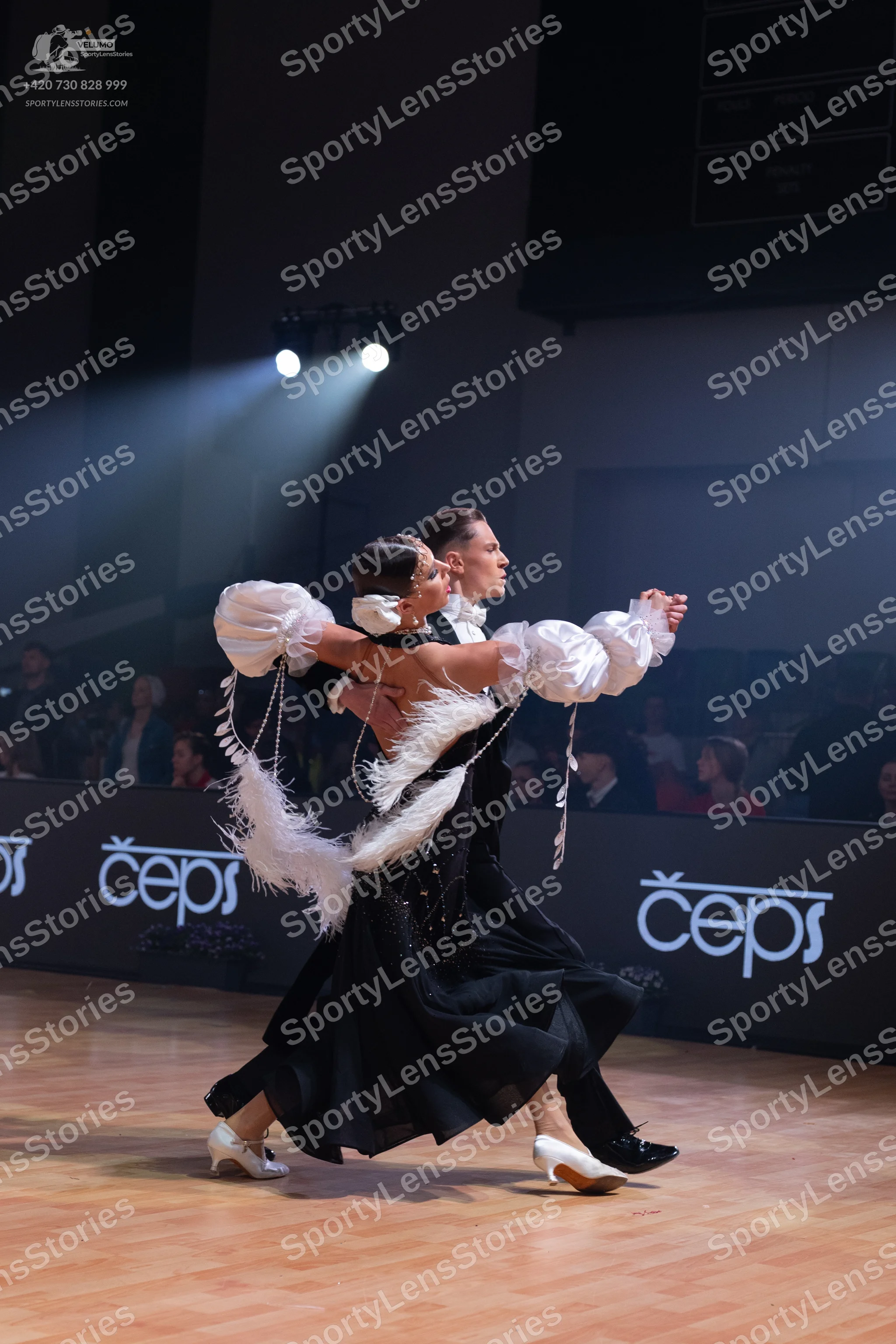 Dancesport competitor: Female dancer: black ballroom dress with voluminous white puffy sleeves adorned