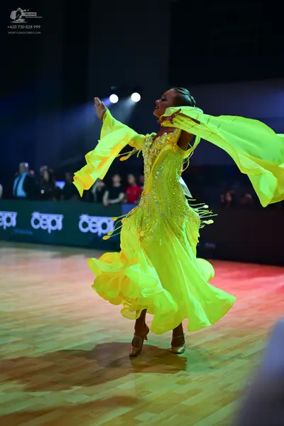 Dancesport competitor: Female dancer: bright yellow latin dance dress with a sequined bodice and a flow